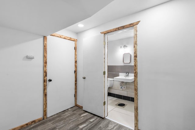 bathroom featuring wood finished floors, a sink, and recessed lighting