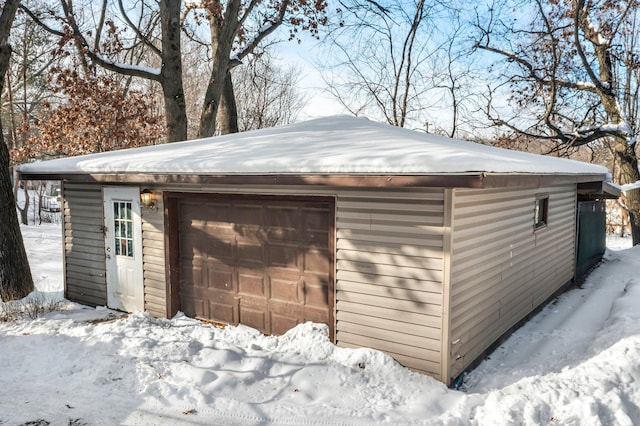 snow covered garage with a detached garage