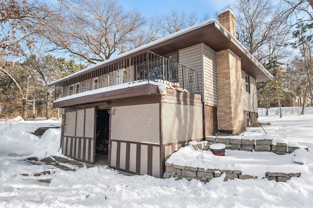 view of snowy exterior featuring a chimney