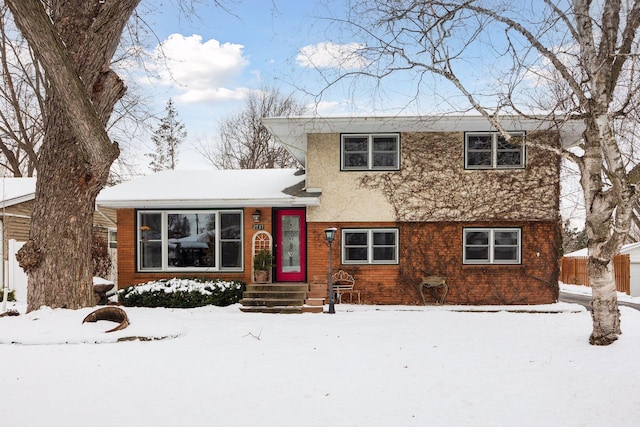 tri-level home featuring fence and stucco siding