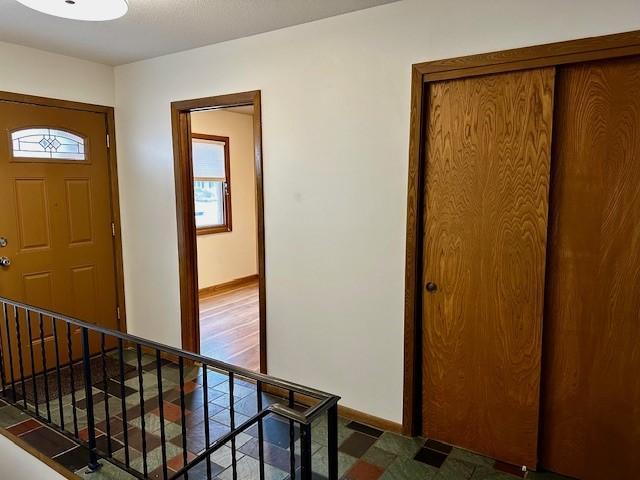 entrance foyer featuring stairway, visible vents, and baseboards