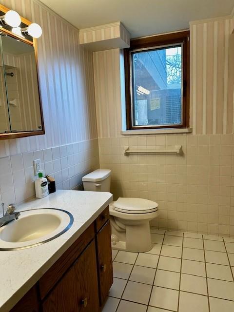 bathroom featuring tile walls, vanity, toilet, and tile patterned floors