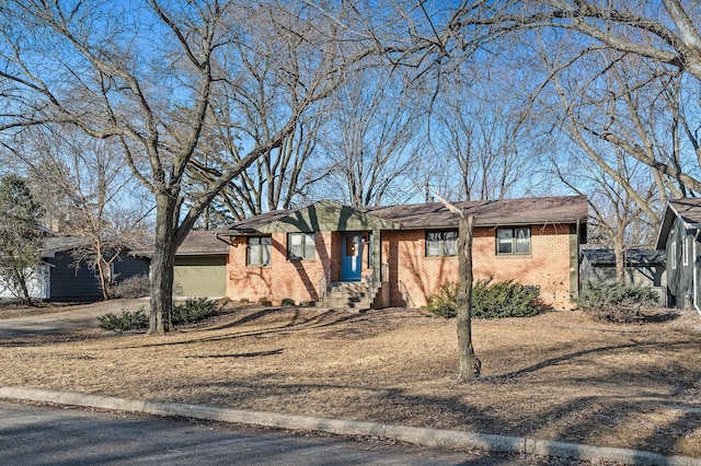 ranch-style house featuring brick siding, a garage, and driveway