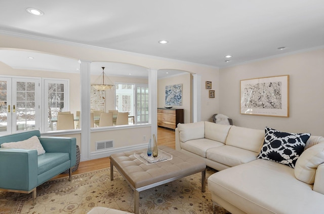 living room featuring visible vents, ornamental molding, wood finished floors, recessed lighting, and ornate columns