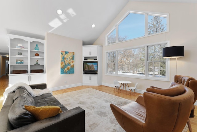 living room with recessed lighting, baseboards, high vaulted ceiling, and light wood finished floors