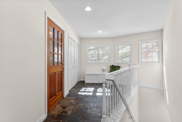 interior space featuring recessed lighting, baseboards, an upstairs landing, and stone finish floor