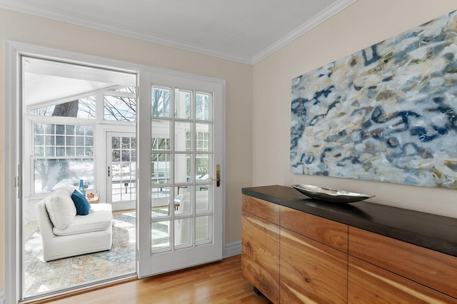 doorway featuring light wood-style floors and ornamental molding