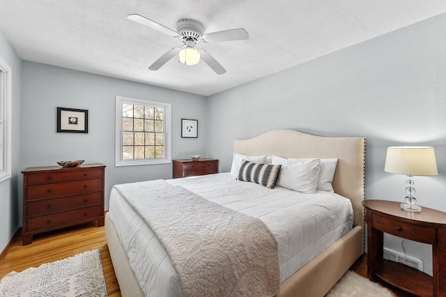 bedroom featuring light wood finished floors, visible vents, and ceiling fan