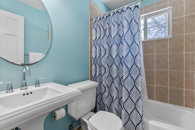 full bath featuring shower / bathtub combination with curtain, toilet, and a sink