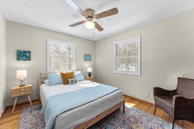 bedroom featuring light wood-style flooring, baseboards, and ceiling fan