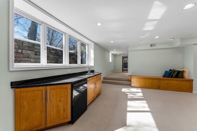 kitchen with visible vents, a sink, black dishwasher, dark countertops, and open floor plan