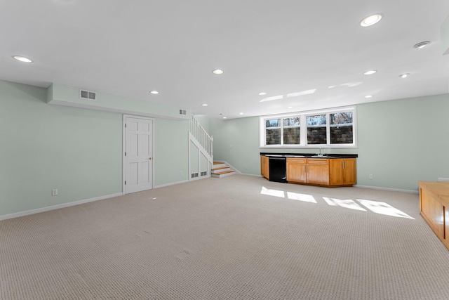 unfurnished living room with visible vents, baseboards, light colored carpet, stairs, and recessed lighting