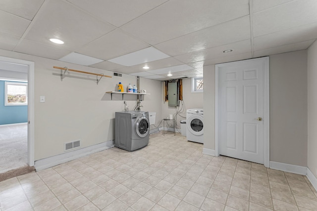 clothes washing area with washing machine and clothes dryer, visible vents, baseboards, electric panel, and laundry area