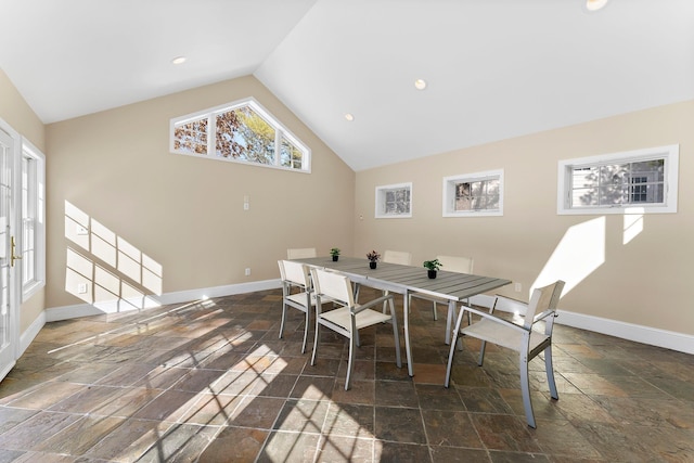 dining area featuring lofted ceiling, recessed lighting, baseboards, and stone tile flooring