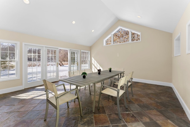 dining space with stone tile floors, recessed lighting, lofted ceiling, and baseboards