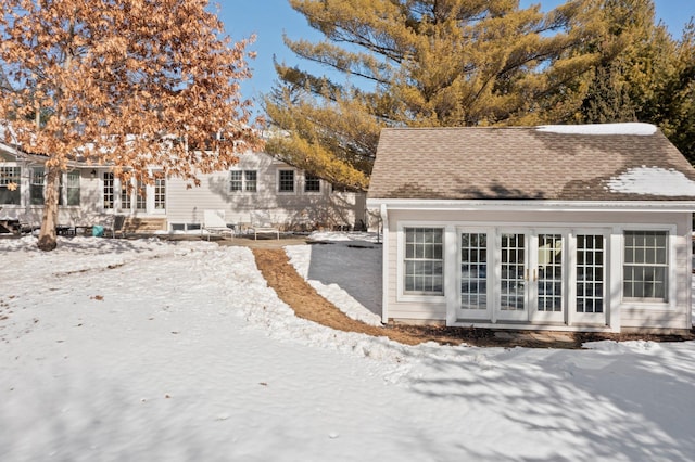 exterior space with french doors and roof with shingles