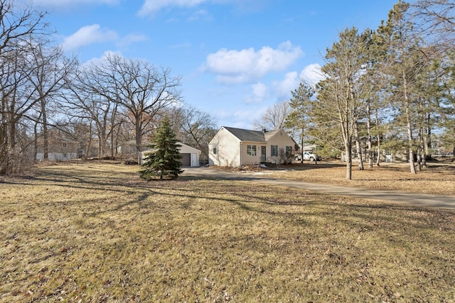 view of front facade with a garage, a front yard, and an outdoor structure