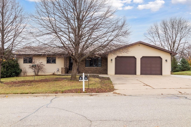 ranch-style house featuring a front lawn, brick siding, driveway, and an attached garage