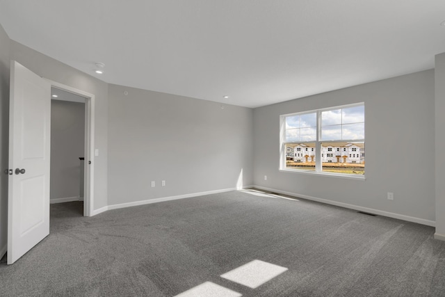 spare room with visible vents, baseboards, and carpet floors