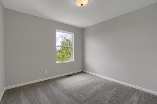 carpeted empty room featuring visible vents and baseboards