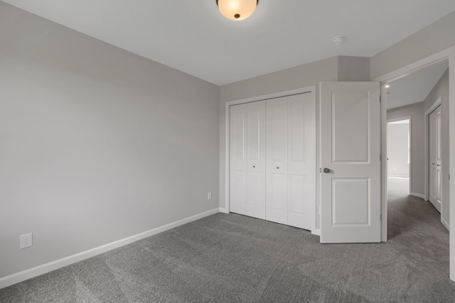 unfurnished bedroom featuring a closet, baseboards, and carpet