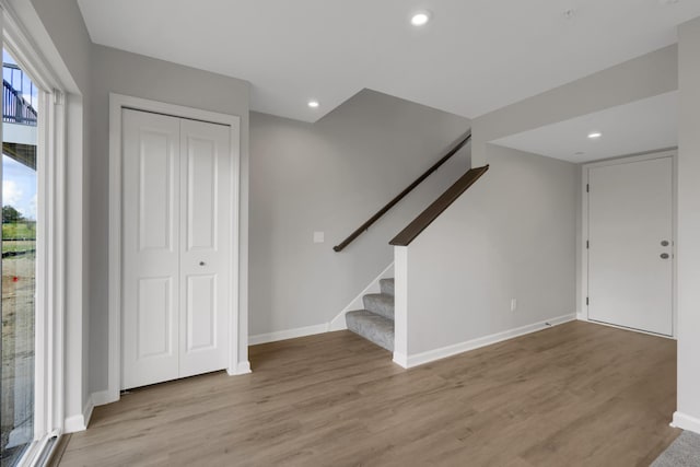 entrance foyer featuring light wood finished floors, stairway, recessed lighting, and baseboards