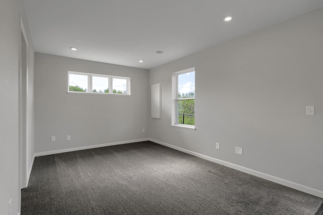 spare room featuring recessed lighting, baseboards, and dark carpet