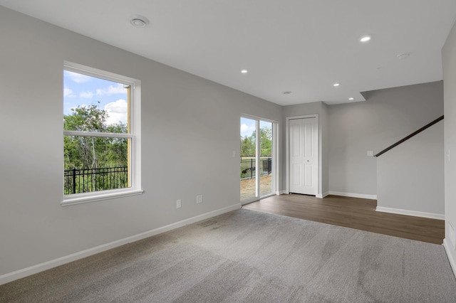 interior space featuring recessed lighting, baseboards, and dark carpet