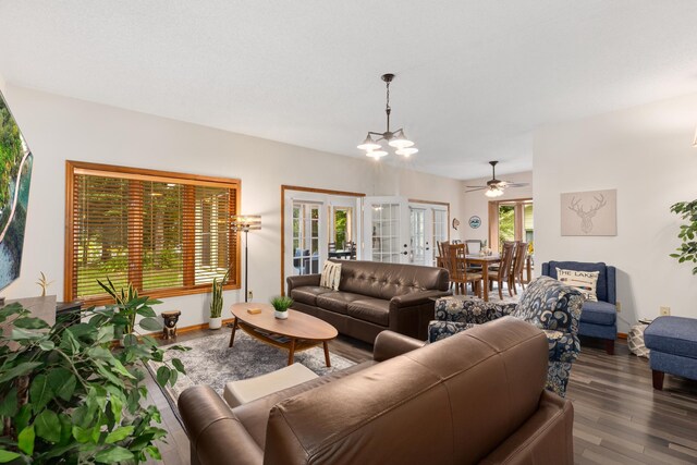 living area featuring dark wood-style floors, baseboards, an inviting chandelier, and french doors