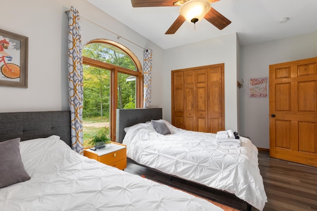 bedroom with dark wood-style floors, ceiling fan, and a closet