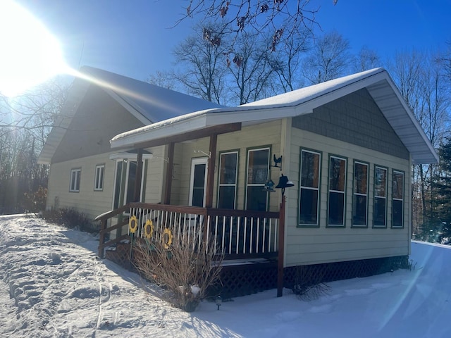 snow covered property featuring covered porch