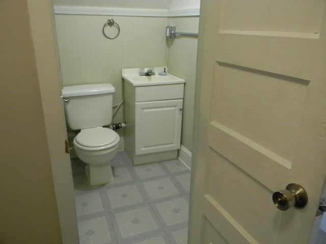 half bath featuring wainscoting, vanity, toilet, and tile patterned floors