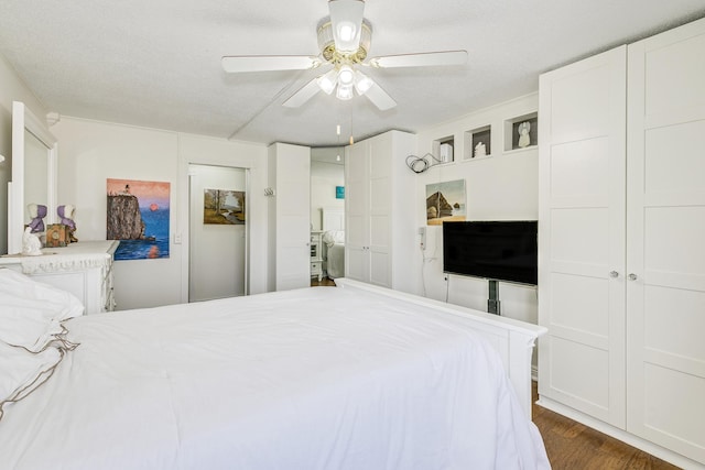 bedroom featuring a textured ceiling, dark wood-style flooring, and a ceiling fan