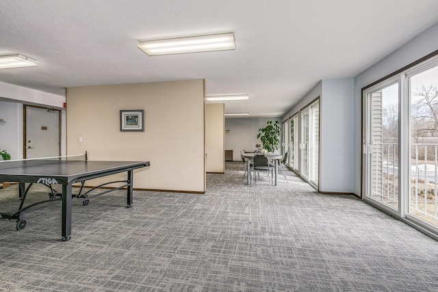 rec room featuring carpet flooring, a textured ceiling, and baseboards