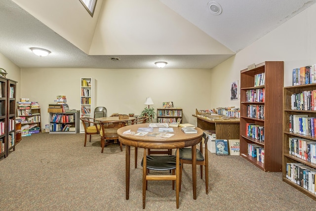 dining room featuring carpet floors, lofted ceiling, visible vents, and a textured ceiling