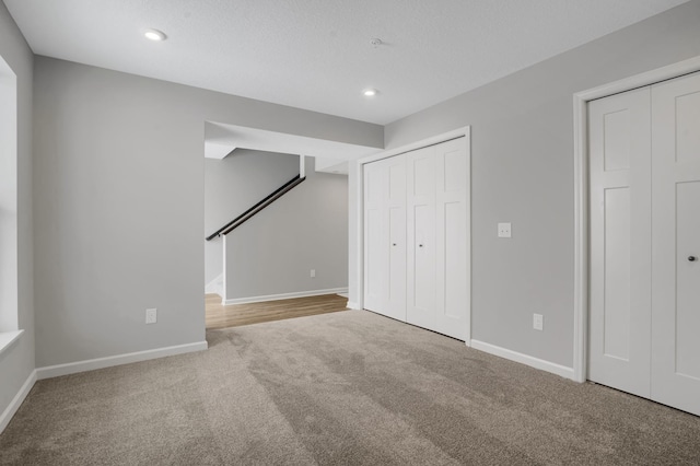 interior space featuring carpet floors, recessed lighting, baseboards, and multiple closets