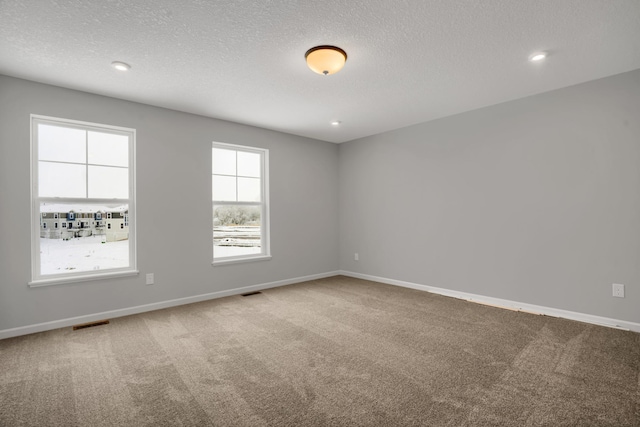 empty room featuring recessed lighting, visible vents, carpet flooring, a textured ceiling, and baseboards