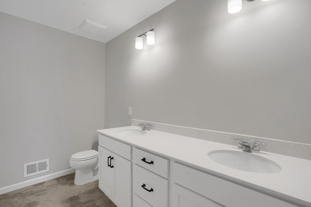 bathroom with toilet, double vanity, a sink, and visible vents