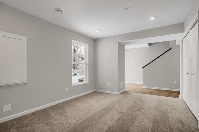 empty room featuring baseboards, recessed lighting, visible vents, and light colored carpet