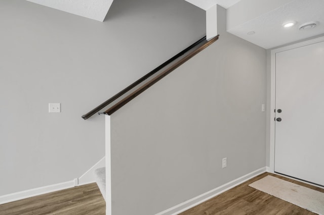 foyer entrance with stairway, baseboards, and wood finished floors