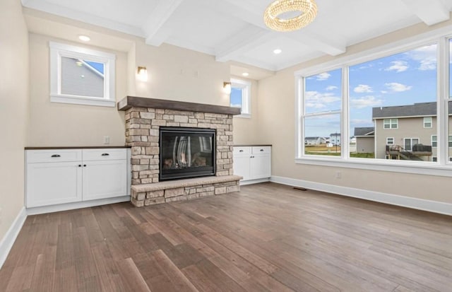 unfurnished living room with baseboards, beam ceiling, and dark wood-style flooring