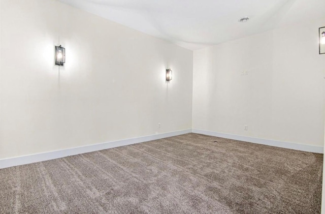 empty room featuring baseboards and carpet floors