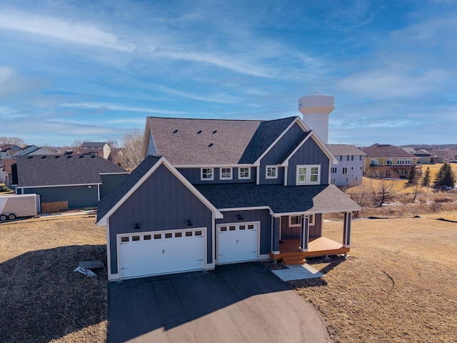 view of front of house featuring driveway, an attached garage, a shingled roof, board and batten siding, and a residential view