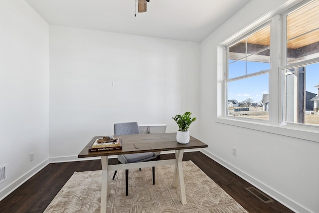 office space featuring visible vents, ceiling fan, baseboards, and dark wood-style flooring