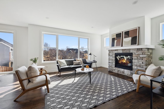 living room featuring baseboards, hardwood / wood-style floors, and a fireplace