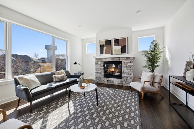 living area with a fireplace, baseboards, and hardwood / wood-style floors