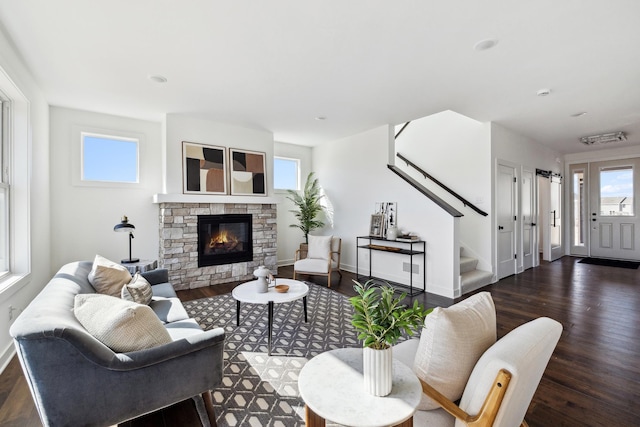 living area featuring stairway, baseboards, a fireplace, and dark wood-style flooring