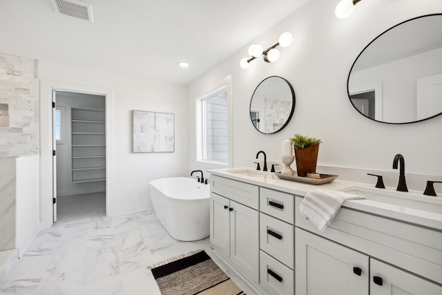 full bath with a sink, visible vents, a soaking tub, and marble finish floor