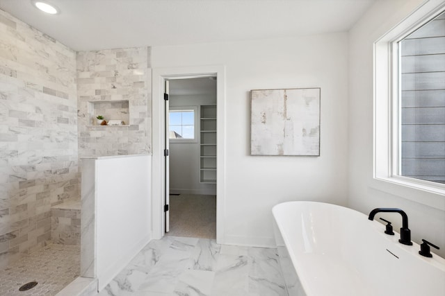 bathroom featuring baseboards, marble finish floor, a freestanding bath, and walk in shower