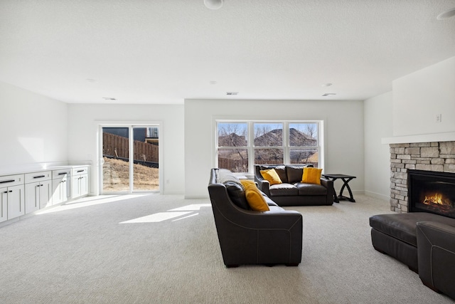 living area with visible vents, baseboards, light colored carpet, and a fireplace